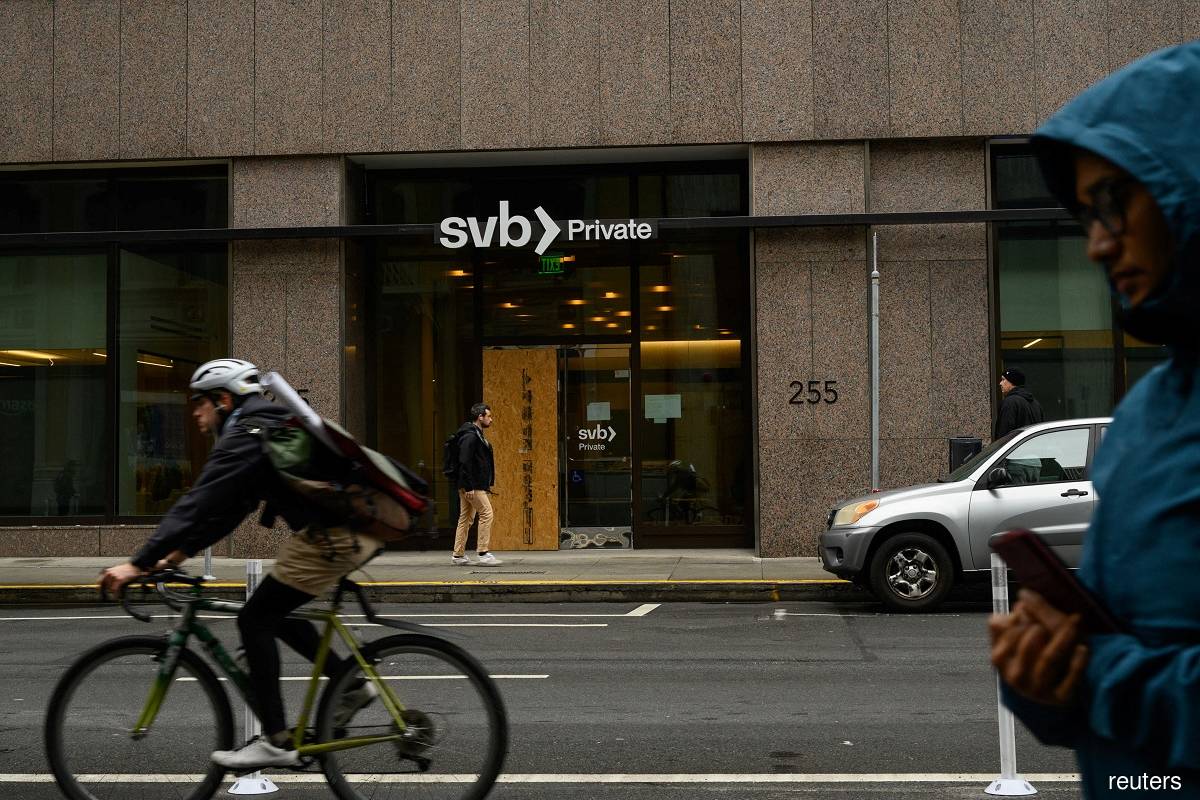 Pedestrians and a cyclist pass by the Silicon Valley Bank branch office in downtown San Francisco March 13, 2023. (Reuters pic)